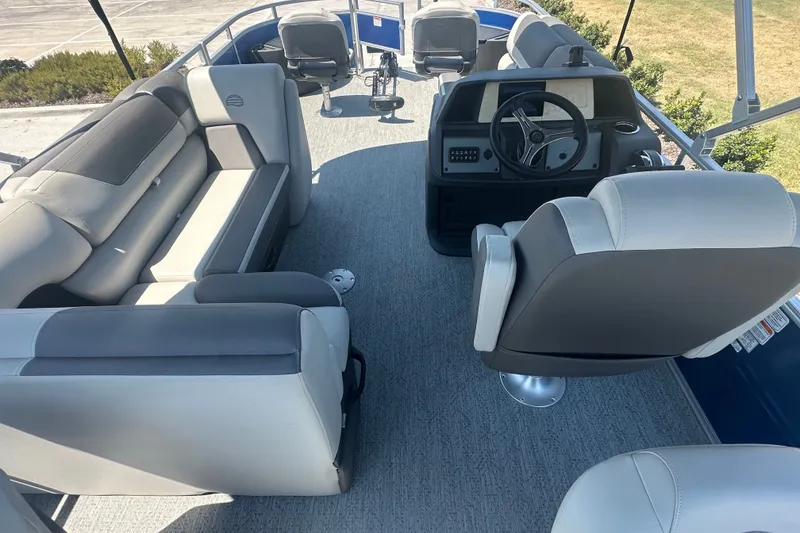 Slide: The Image of 2026 Sun Tracker Fishin' Barge 20 DLX interior with seating and steering console. - 22