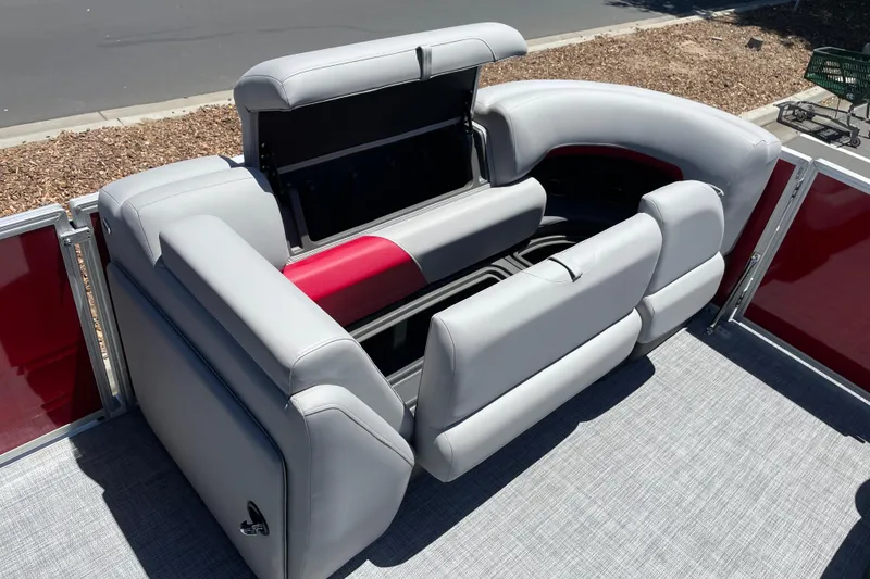Slide: The Image of 2026 Sun Tracker Party Barge 20 DLX with gray and red seating, open storage compartment. - 8