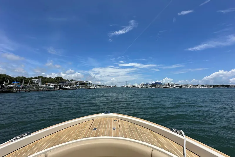 Slide: The Image of Bow view from 2015 Chris-Craft 291 Catalina, overlooking marina under clear blue sky. - 17