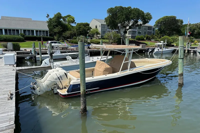 Slide: The Image of 2015 Chris-Craft 291 Catalina docked at a marina, surrounded by calm waters and scenic views. - 20
