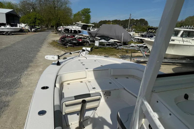 Slide: The Image of 2023 Robalo 246 Cayman boat at a marina with surrounding boats and trailers. - 19