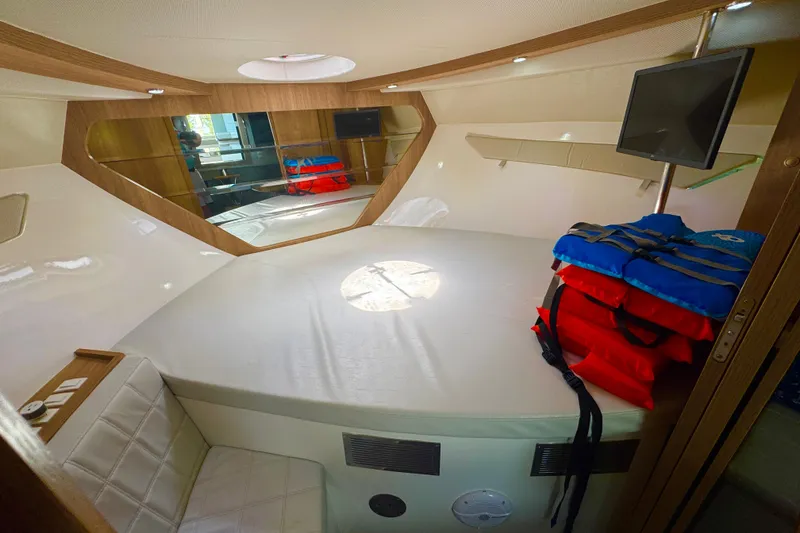 Slide: The Image of Interior of 2020 Evolve 360HT boat cabin with bed, life jackets, and TV. - 15