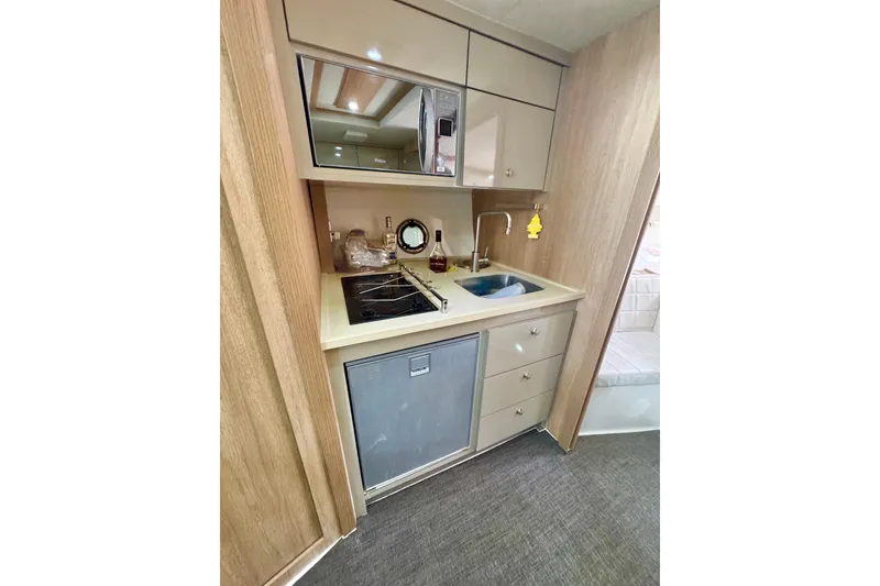 Slide: The Image of Compact kitchen in 2020 Evolve 360HT RV with stove, sink, and storage cabinets. - 18