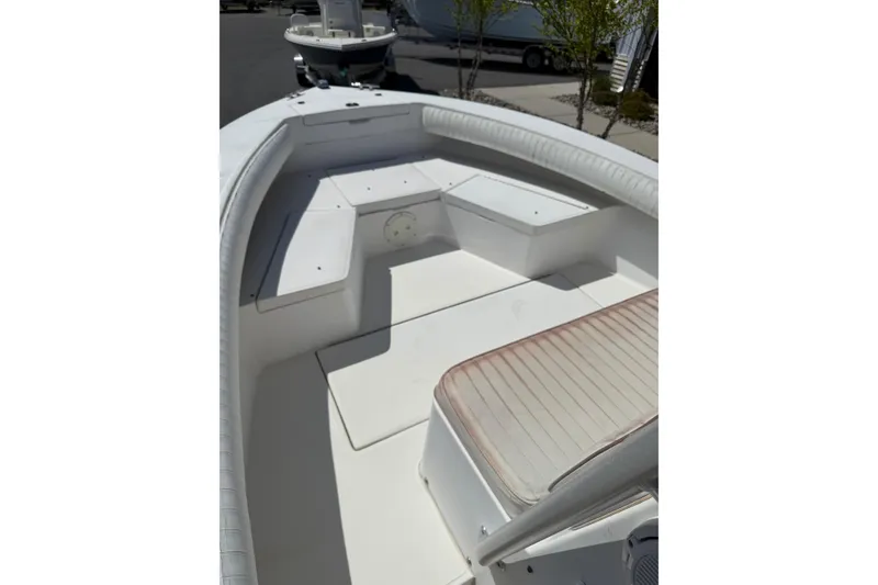 The Image of 2004 Regulator 21 Forward Seating boat interior with white cushioned seats and storage compartments. - 1