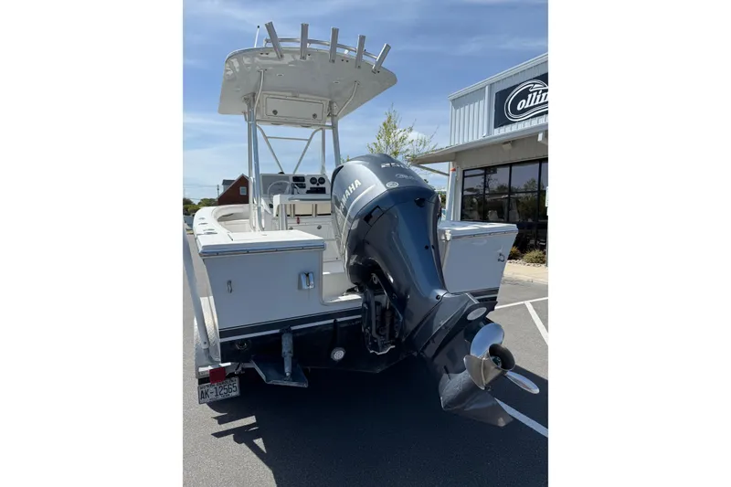 Slide: The Image of 2004 Regulator 21 Forward Seating boat with Yamaha outboard motor, parked outside a building. - 10