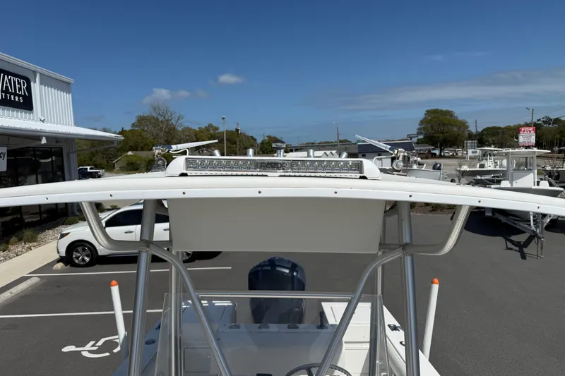 Slide: The Image of 2004 Regulator 21 Forward Seating boat with T-top and LED light bar in parking lot. - 2