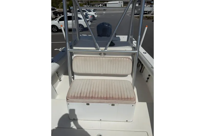 Slide: The Image of 2004 Regulator 21 Forward Seating boat with cushioned bench and metal frame in a parking lot. - 3