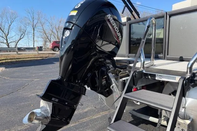 Slide: The Image of Outboard motor on a 2026 Alera A22Q boat with ladder, parked outdoors. - 6