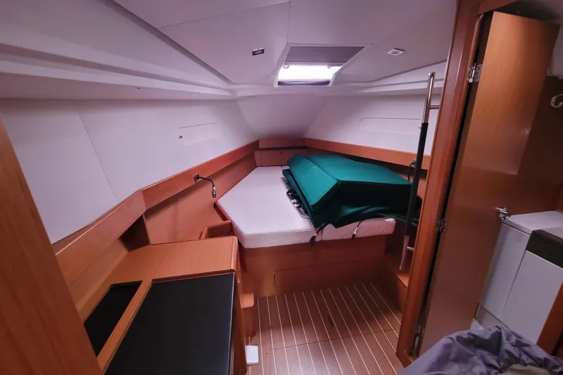 Slide: The Image of Interior cabin of 2017 Jeanneau Sun Odyssey 44 DS yacht, featuring a cozy bed and wooden finish. - 27