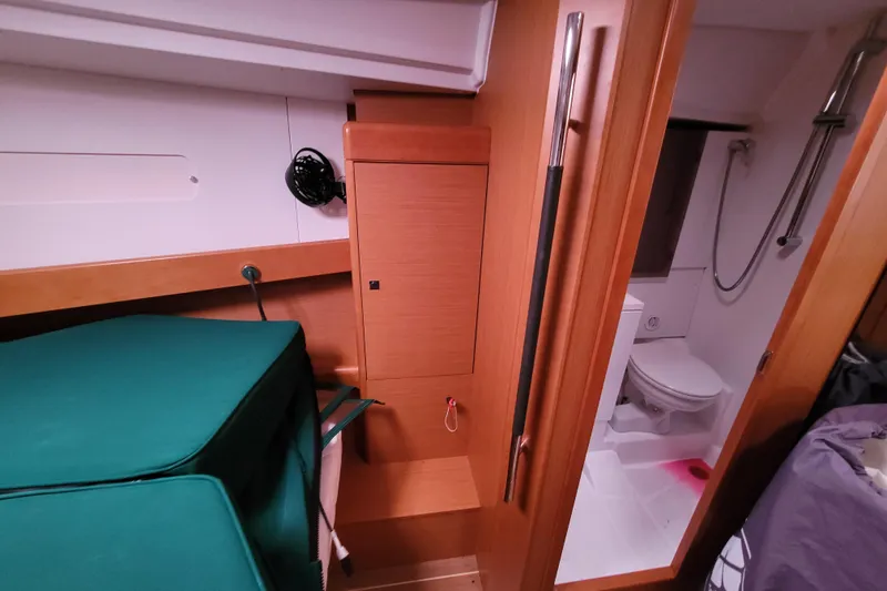 Slide: The Image of Interior of 2017 Jeanneau Sun Odyssey 44 DS yacht, featuring a compact bathroom and wooden cabinetry. - 28