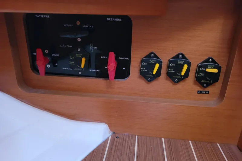 Slide: The Image of Control panel of a 2017 Jeanneau Sun Odyssey 44 DS sailboat, featuring battery switches and breakers. - 63