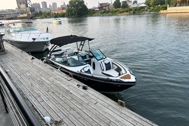 Slide: The Image of 2020 Monterey 278SS Super Sport boat docked by a wooden pier in a city harbor. - 3