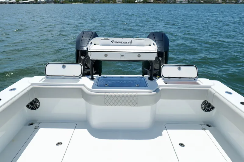 Slide: The Image of 2023 Freeman 34VH boat deck with open storage compartments on a calm lake. - 13