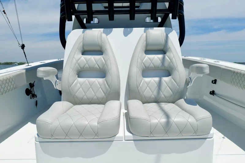 Slide: The Image of Luxury seating on 2023 Freeman 34VH boat, featuring diamond-stitched upholstery and integrated cup holders. - 17