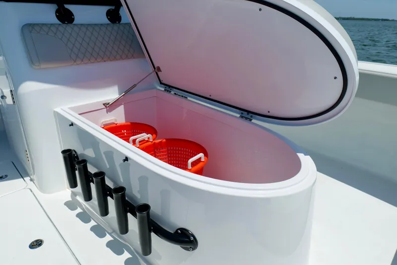 Slide: The Image of Open storage compartment on 2023 Freeman 34VH boat with red baskets inside. - 31