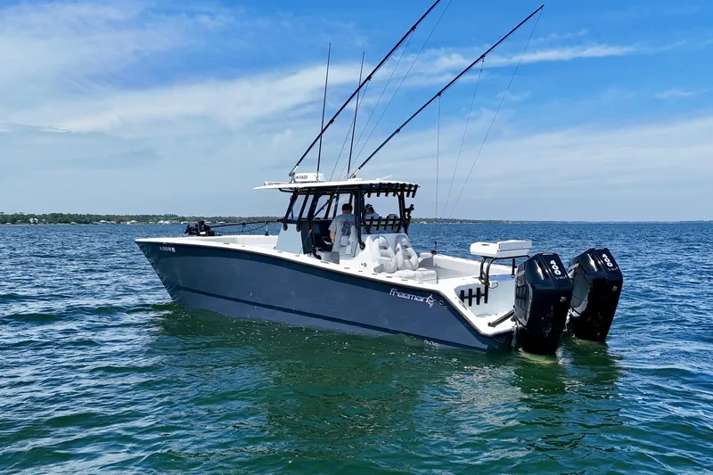 Slide: The Image of 2023 Freeman 34VH boat on open water, featuring dual engines and fishing rods. - 8
