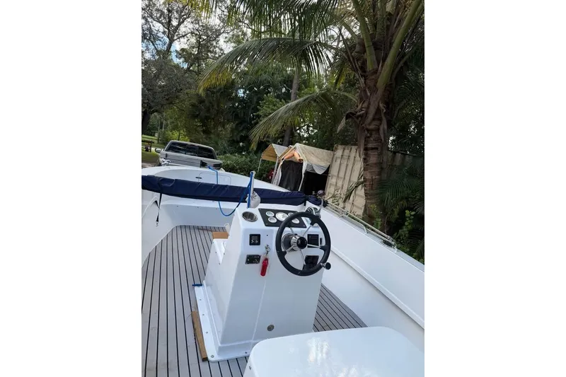 Slide: The Image of 1968 Donzi 18 Classic boat with steering wheel, docked near palm trees. - 4