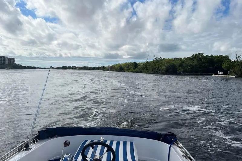 Slide: The Image of 1968 Donzi 18 Classic boat cruising on a scenic river under a cloudy sky. - 7