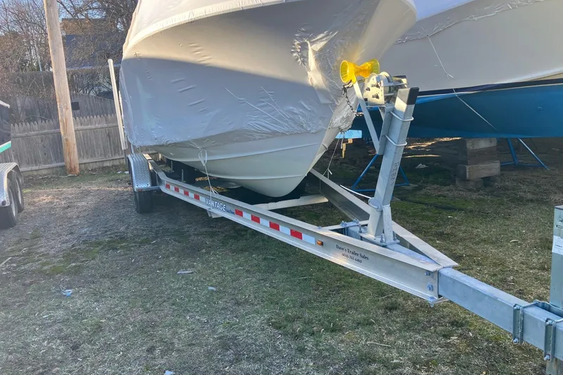 Slide: The Image of 2006 Regulator 24 Forward Seating boat on trailer, covered and parked outdoors. - 11