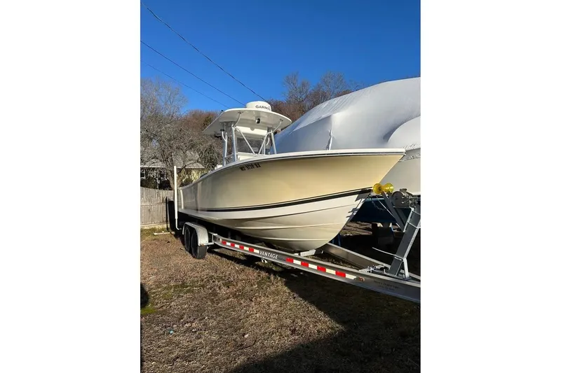 Slide: The Image of 2006 Regulator 24 Forward Seating boat on trailer under clear blue sky. - 2