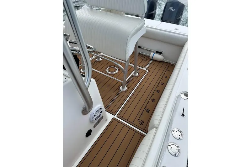 Slide: The Image of 2006 Regulator 24 Forward Seating boat interior with teak flooring and white seating. - 3