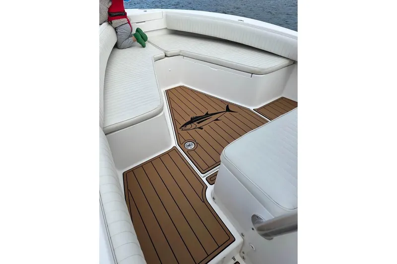Slide: The Image of 2006 Regulator 24 Forward Seating boat interior with cushioned seats and fish design flooring. - 8