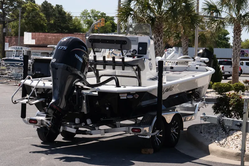 Slide: The Image of Avid 21 Mag 2026 boat with Yamaha 175 engine on trailer, parked outdoors. - 11