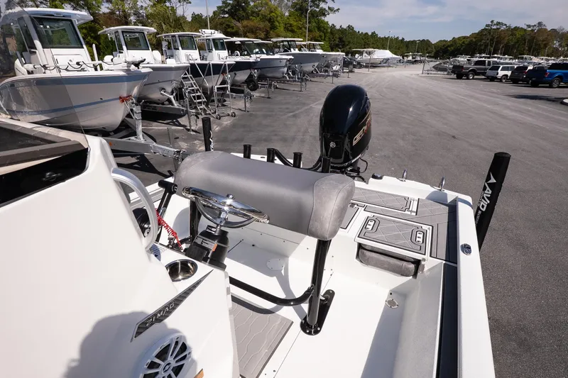 Slide: The Image of Avid 21 Mag 2026 boat interior with steering wheel and seating, parked among other boats. - 15