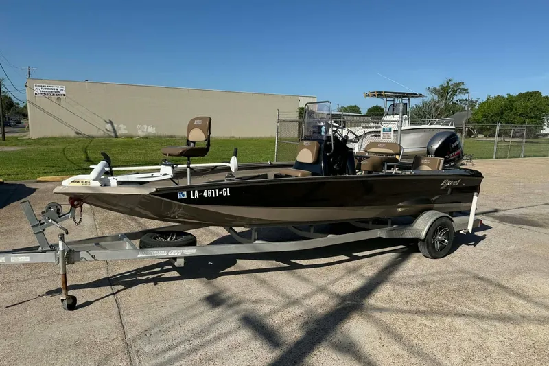 The Image of 2020 Excel 203 Bay Pro boat on trailer, parked outdoors under clear blue sky. - 0