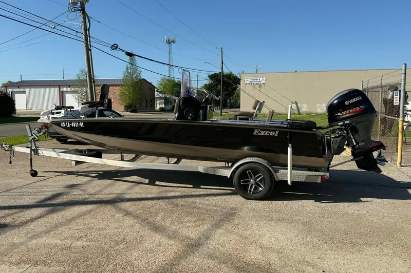 Slide: The Image of 2020 Excel 203 Bay Pro boat on trailer with Yamaha outboard motor, parked outdoors. - 2