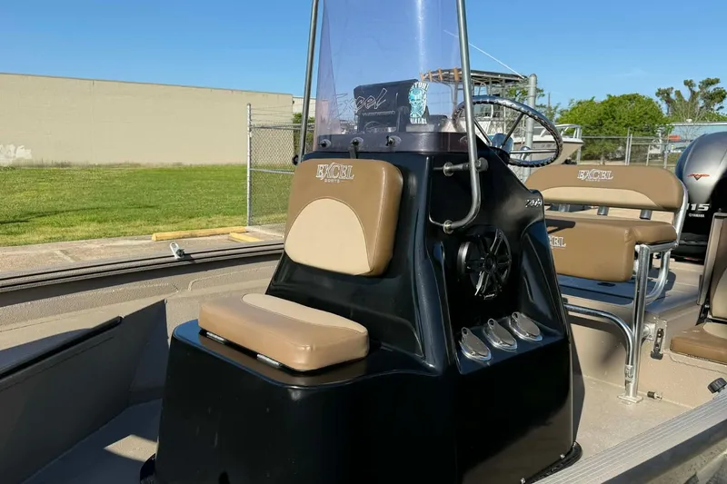 Slide: The Image of 2020 Excel 203 Bay Pro boat interior with tan seating and steering console. - 3