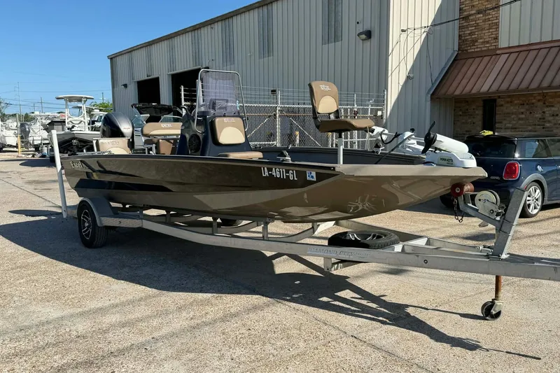 Slide: The Image of 2020 Excel 203 Bay Pro boat on trailer, parked outside a warehouse. - 5
