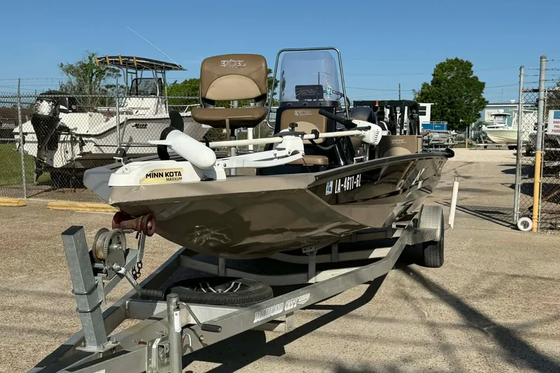 Slide: The Image of 2020 Excel 203 Bay Pro boat on trailer with Minn Kota motor in a marina. - 7