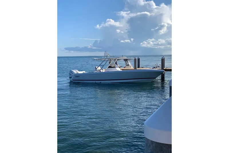 Slide: The Image of 2016 Intrepid 327 Center Console boat docked on calm ocean waters. - 1