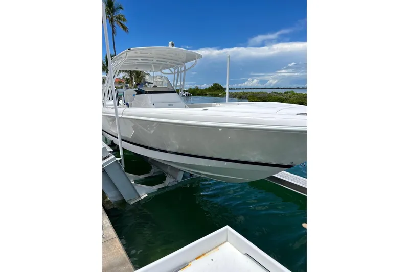 Slide: The Image of 2016 Intrepid 327 Center Console boat docked by tropical waters. - 2