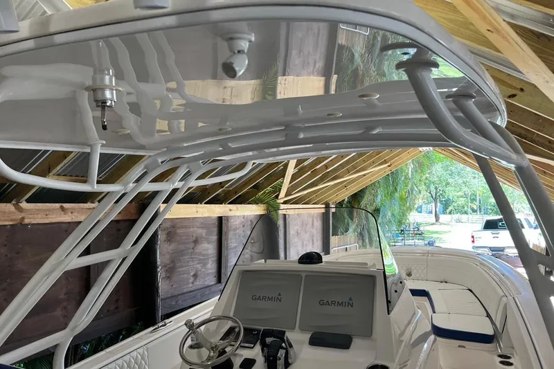 Slide: The Image of 2016 Intrepid 327 Center Console boat with Garmin navigation, under a wooden shelter. - 4