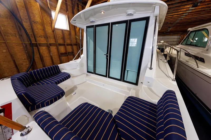 Slide: The Image of 2011 Back Cove 37 boat interior with striped seating in a wooden boathouse. - 10