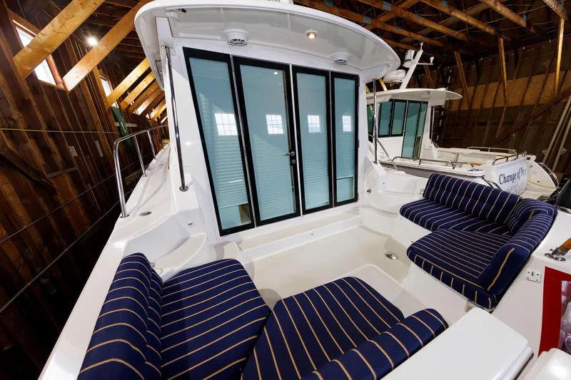 Slide: The Image of 2011 Back Cove 37 boat interior with striped seating in a wooden boathouse. - 12