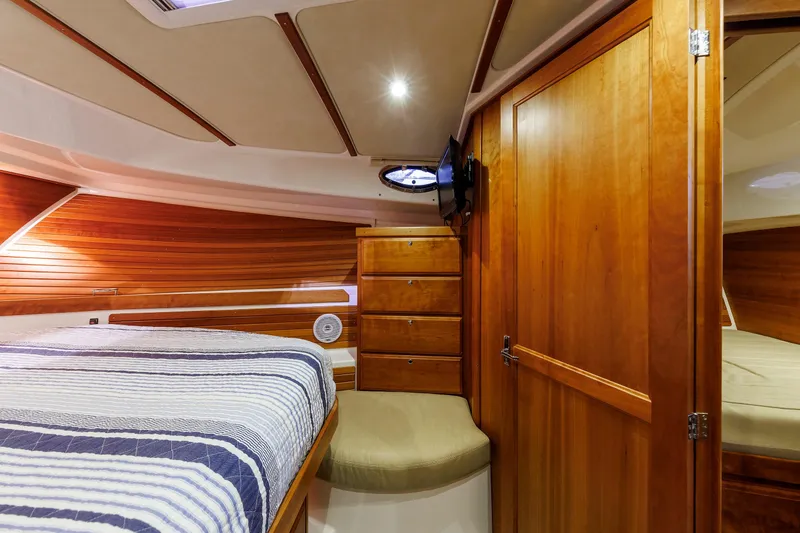 Slide: The Image of Luxurious 2011 Back Cove 37 yacht cabin with wood paneling and cozy bed. - 19