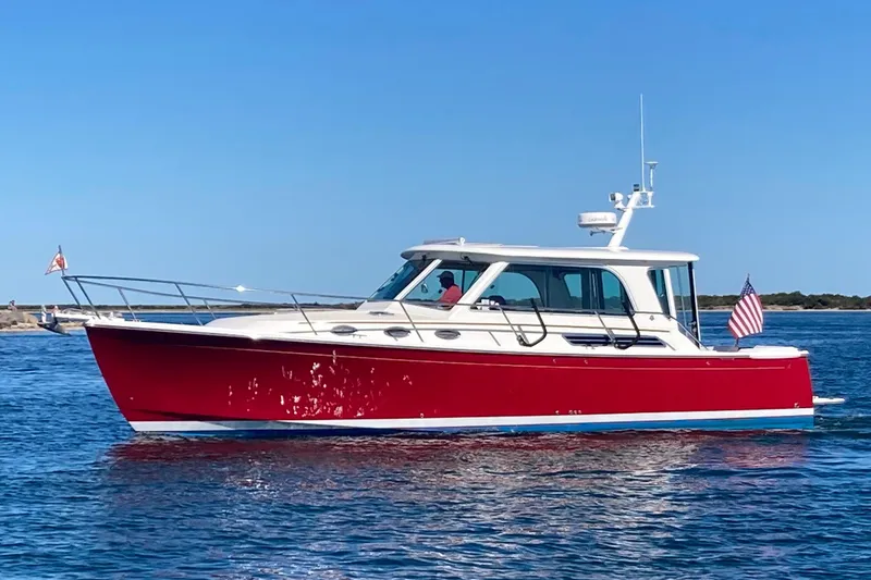 Slide: The Image of Red 2011 Back Cove 37 boat cruising on calm blue waters under clear skies. - 2