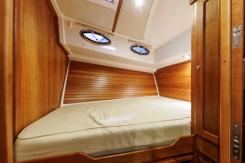 Slide: The Image of Cozy cabin interior of 2011 Back Cove 37 boat with wooden paneling and portholes. - 25