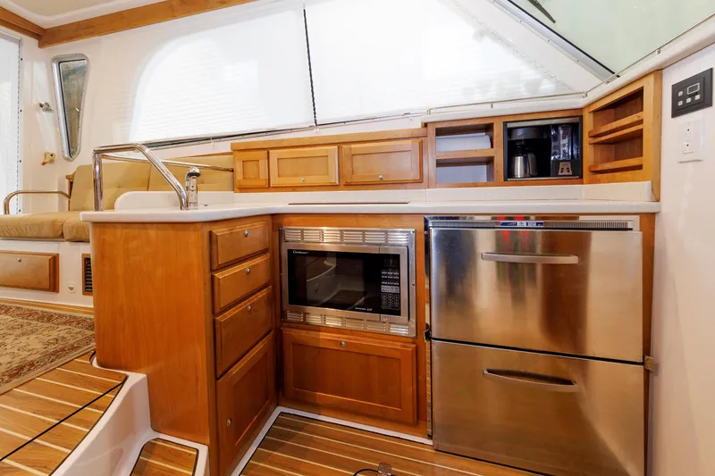 Slide: The Image of 2011 Back Cove 37 yacht kitchen with wood cabinetry, stainless steel appliances, and modern fixtures. - 29