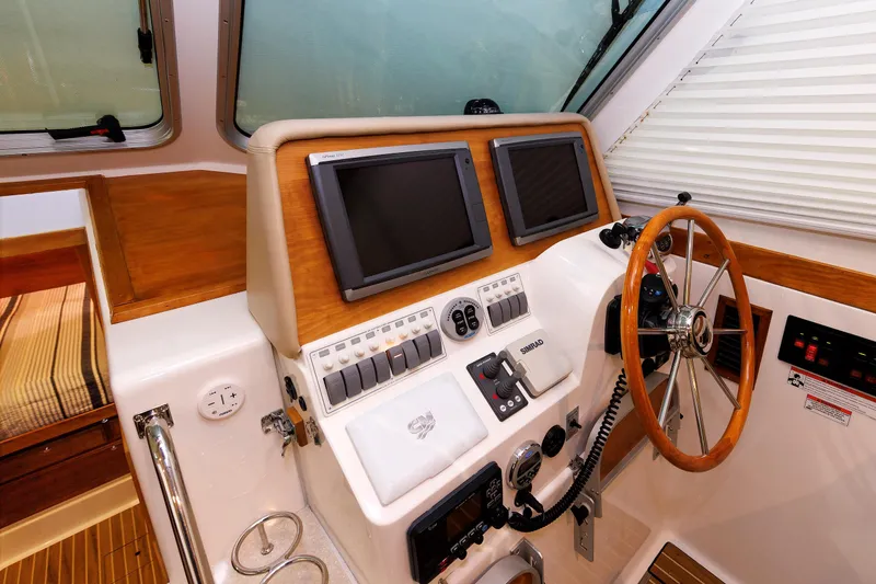 Slide: The Image of Helm of 2011 Back Cove 37 boat with dual screens and wooden steering wheel. - 31