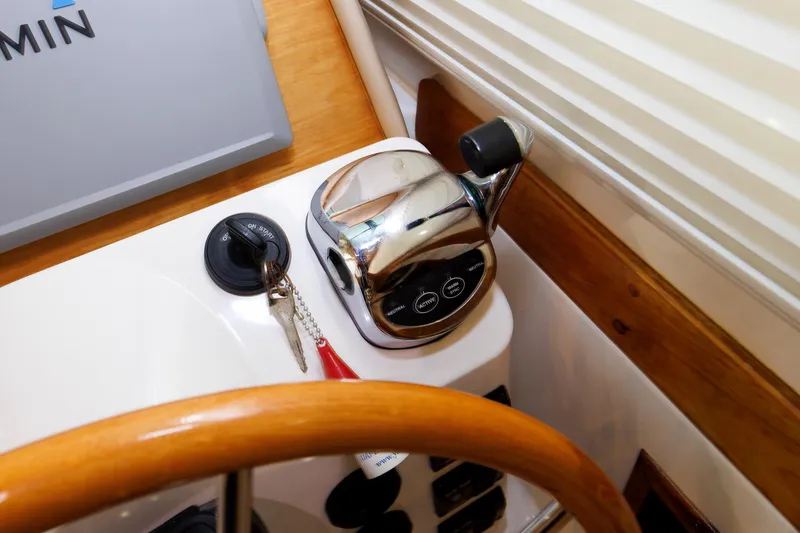 Slide: The Image of 2011 Back Cove 37 helm with throttle, ignition keys, and Garmin navigation system. - 34