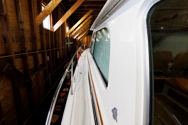 Slide: The Image of 2011 Back Cove 37 yacht in wooden boathouse, side view with railing and windows. - 9