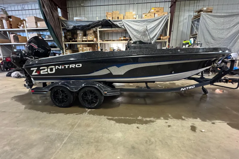 The Image of 2020 Nitro ZV20 boat in warehouse, black with dual-axle trailer. - 0