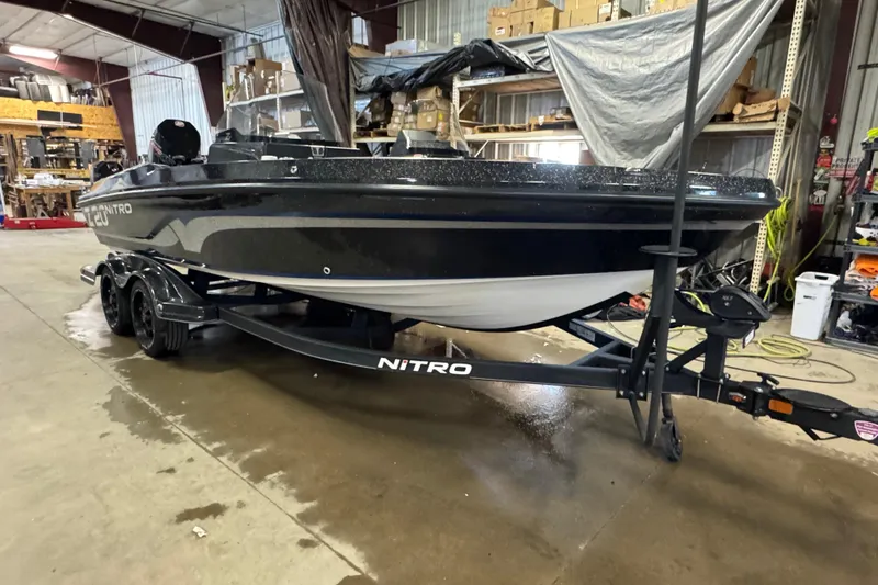 Slide: The Image of 2020 Nitro ZV20 boat in a warehouse, black exterior, on a trailer. - 2