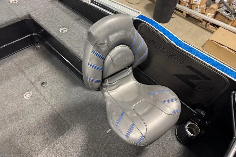 Slide: The Image of Gray seat in a 2020 Nitro ZV20 boat, featuring blue accents and carpeted flooring. - 7