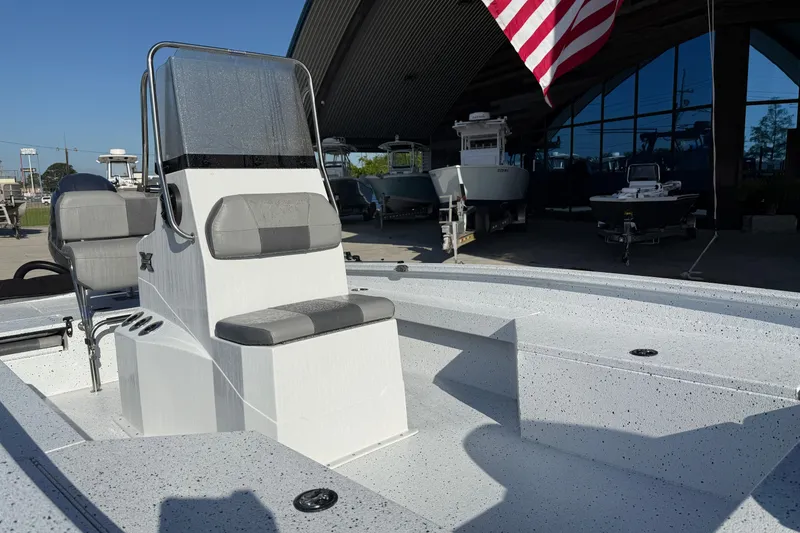 Slide: The Image of 2023 Xpress H22B Bay boat with seating, displayed outdoors under a large roof. - 9