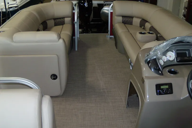 Slide: The Image of 2023 Sun Tracker Party Barge 20 DLX interior with beige seating and control panel. - 2